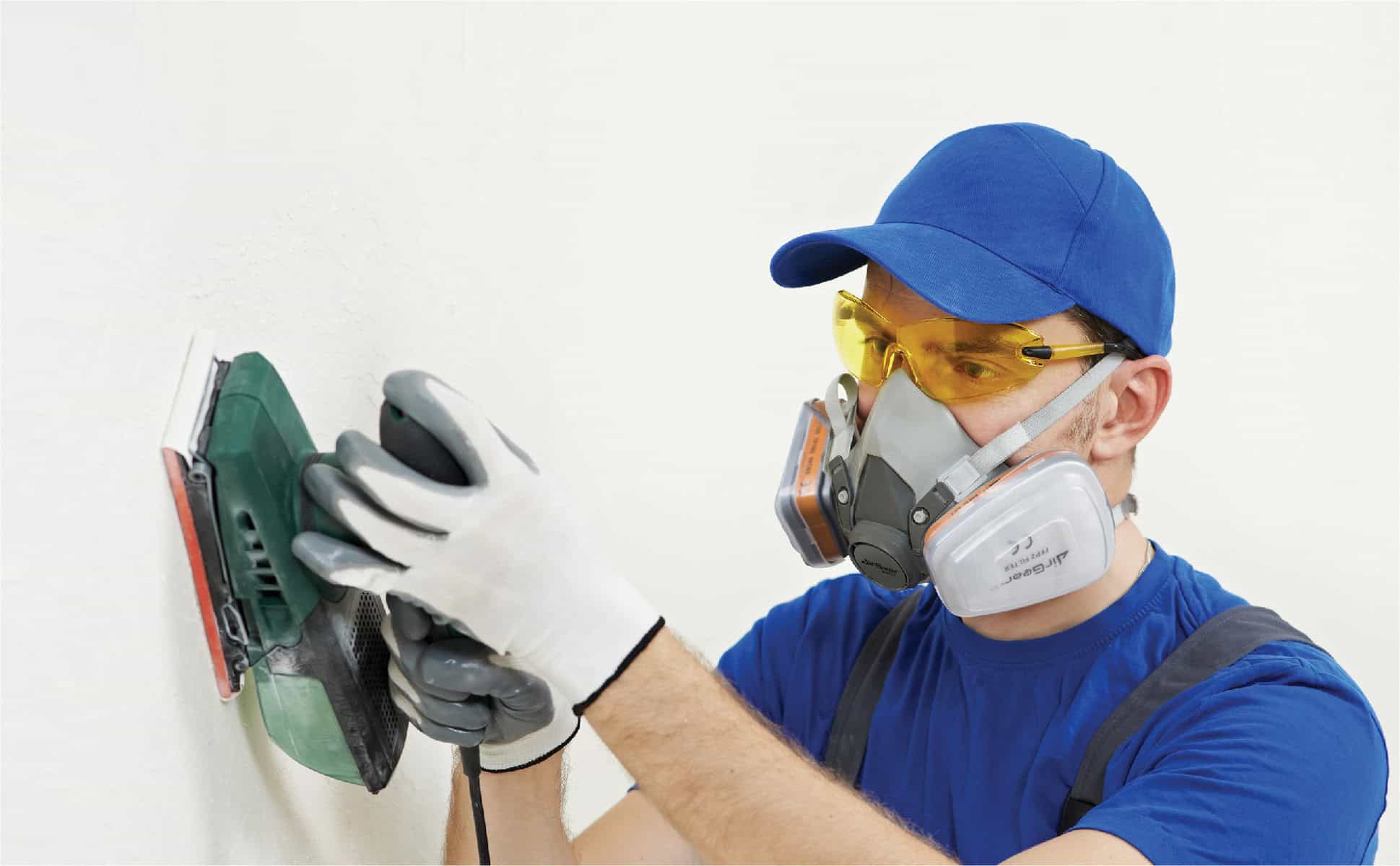 Electric wall sander for home renovation and wall finishing, using AirGearPro safety gear, including a respirator mask and protective goggles for dust and debris protection.